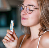 Woman using CBD lip balm to protect her lips
